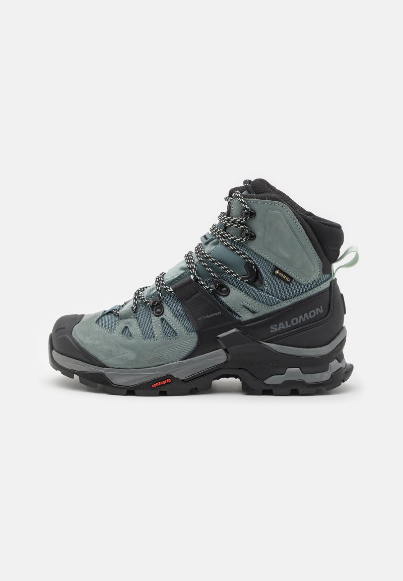 Botas de caminhadas de cano alto em cinza-azul com upper em camurça e malha, apresentando detalhes em preto, atacadores trançados e uma sola robusta para tração.