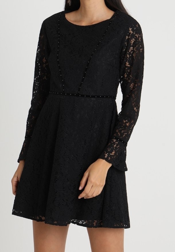 Robe longue en dentelle noire à manches longues, taille cintrée, jupe évasée, avec des détails subtils de perles le long de l'encolure et de la taille.