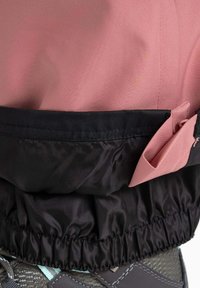 Rosa und schwarze Windjacke mit einem gerafften Saum, die eine strukturierte Oberfläche und kontrastierende Stoffabschnitte aufweist. Enthält Taschendetails.