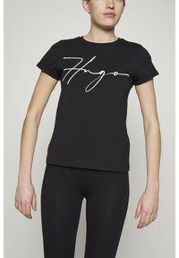 Schwarzes Baumwoll-T-Shirt mit einem weißen, geschwungenen Logo über der Brust. Kurzärmlig mit umgeschlagenen Ärmeln. Taillierte Passform, glatte Textur.