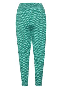 Turkosa byxor med ett geometriskt mönster, med en rynkad midja, avsmalnande ben och elastiska manchetter vid anklarna.