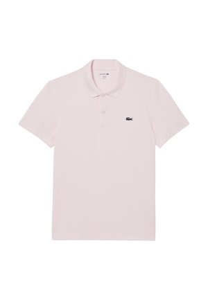 Camisa polo rosa claro hecha de algodón. Presenta un cuello, mangas cortas y un logotipo negro de Lacoste en el pecho izquierdo. Diseño básico, color sólido.