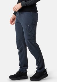 Navy cargo pants with zip pockets, made from lightweight fabric. Features a relaxed fit, flat seams, and reinforced stitching for durability.