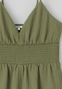 Robe vert olive avec un tissu texturé et froissé, dotée d'une taille smockée et d'un décolleté en V, de fines bretelles réglables et d'un ourlet évasé.