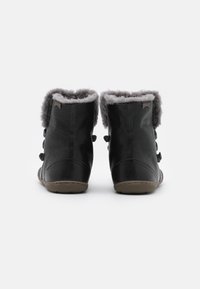 Czarne botki za kostkę wykonane z fakturowanej skóry, z szarym futrzanym wyściółką, wyposażone w trzy guziki po bokach i beżową gumową podeszwę.