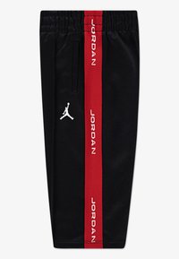 Black shorts made of soft fabric featuring a red side stripe with "JORDAN" text, elastic waistband, and white Jumpman logo on the front.