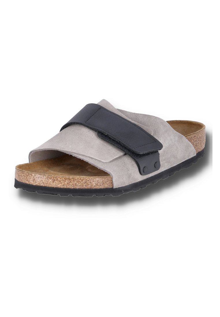 Grau Wildleder Slide-Sandale mit einem schwarzen verstellbaren Riemen, Korkfußbett und Gummisohle. Verfügt über ein flaches Design und strukturierte Materialien.