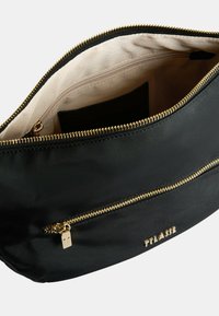 Borsa nera con zip realizzata in materiale liscio, con zip e dettagli dorati. L'interno presenta una fodera chiara e una tasca con zip.