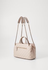 Borsa beige trapuntata con doppi manici in pelle e una tracolla in catena dorata. Presenta una tasca con zip sulla parte anteriore e una texture liscia.