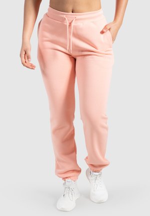 Light pink sweatpants with elastic waistband and drawstring. Soft fabric with side pockets and elastic cuffs at the ankles.