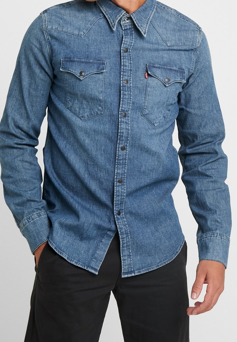 Jeansskjorta i mellanblått, med tryckknapps-stängning, två bröstfickor och en västerninspirerad yoke-design med långa ärmar.