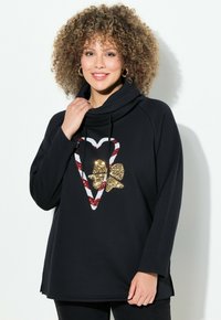 Sudadera negra con cuello tipo cowl, adornada con un diseño de corazón brillante en rojo y blanco y un apliqué de mariposa dorada. Manga larga y corte relajado.