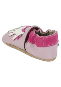 Weiche Lederschuhe in Hellrosa mit einem strukturierten, rosa Wildlederband, elastischer Öffnung und einer weißen Handform-Applikation an der Seite.