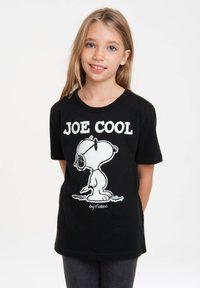 Black cotton t-shirt featuring a graphic of Snoopy wearing sunglasses, with the text "JOE COOL" in white above, and "by Schulz" below.