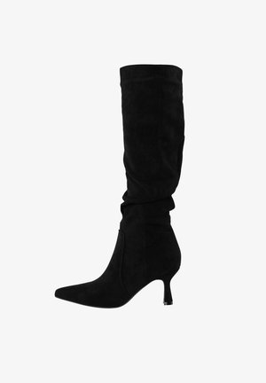 Sort mokkasinskin midt-kalvsstøvle med spids tå og slank lav hæl, let bøjet skaft, set fra siden mod hvid baggrund.