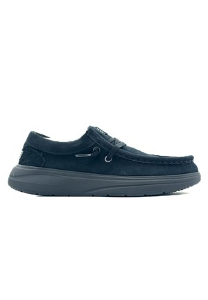 Chaussure noire en daim avec un laçage, accents texturés, semelle en caoutchouc épaisse et coutures sur les bords, dotée d'un bout arrondi.