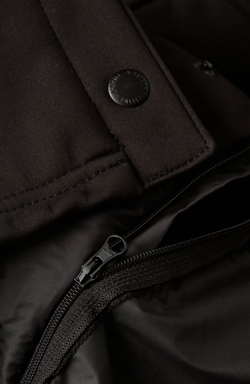 Schwarzer Stoff mit matter Textur zeigt eine Nahaufnahme eines Reißverschlusses und eines Druckknopfverschlusses auf einer Tasche.