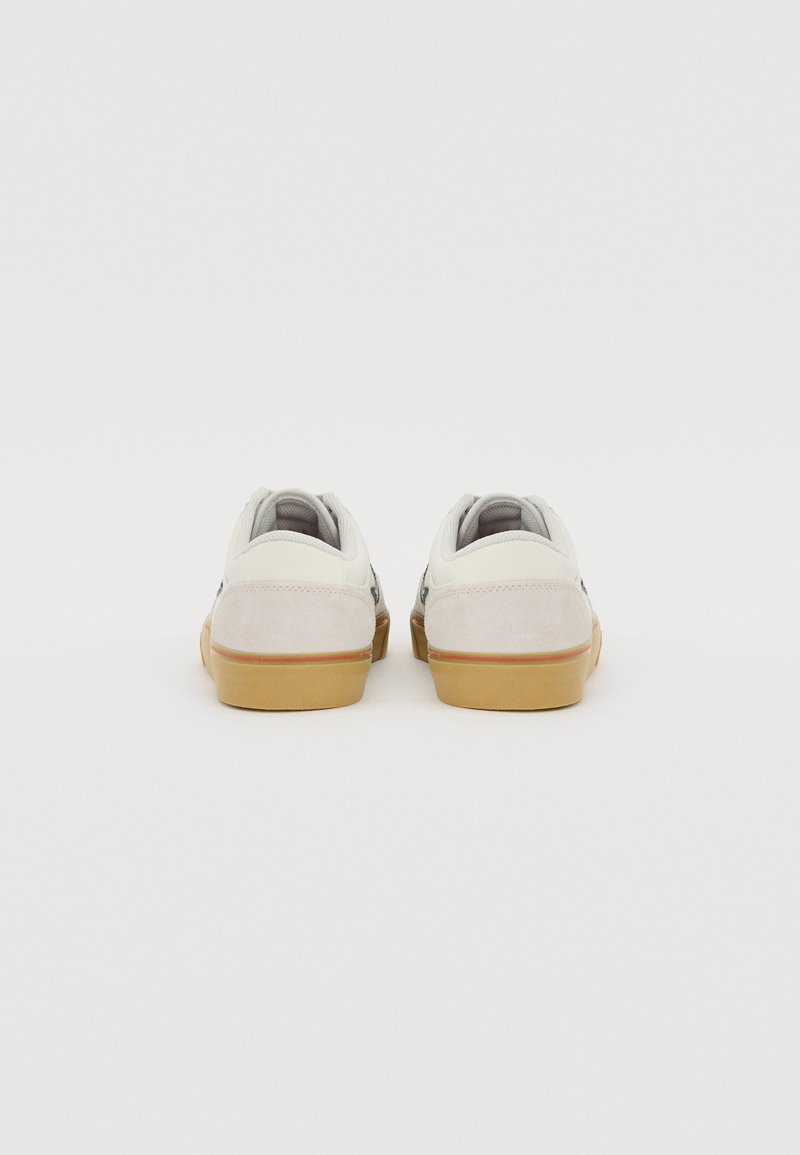 Zapatillas para hombre con parte superior de cuero blanco, acentos de gamuza gris, suela de goma beige y un diseño de perfil bajo con cierre de cordones.