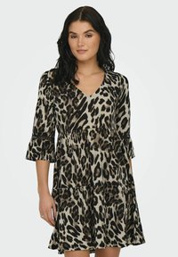 Robe à imprimé léopard avec un décolleté en V, des manches trois-quarts et un ourlet à volants. Fabriquée en tissu doux, avec des tons noir et beige.