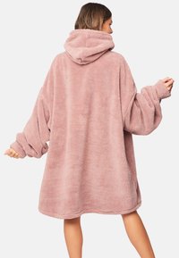 Abito felpa oversize rosa con maniche lunghe e tasca a marsupio, caratterizzato da una consistenza morbida e un design rilassato.