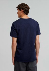 T-shirt blu navy a maniche corte con scollatura a girocollo, realizzato in un tessuto testurizzato. Il retro presenta una vestibilità comoda e un design semplice.