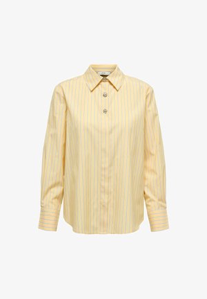 Dzeltena krekla ar vertikālām zilām svītrām, ar izteiktiem apkakli, garajām piedurknēm un trim mirdzošiem pogu aiztaisījumiem.