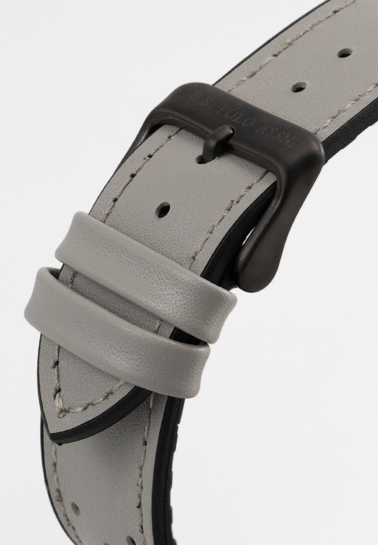 Sangle de montre en cuir gris avec des accents noirs, dotée d'une boucle en métal et de deux retenues en cuir pour un maintien sécurisé. Détails de couture visibles.