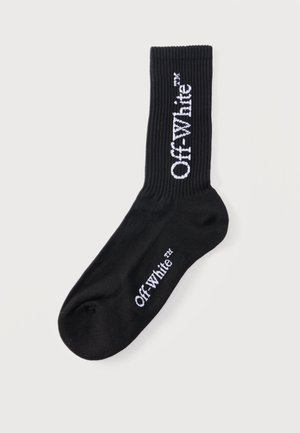 Schwarze Sportsocke mit geripptem Bündchen, mit weißem "Off-White™" Schriftzug an der Seite und am oberen Fußbereich.