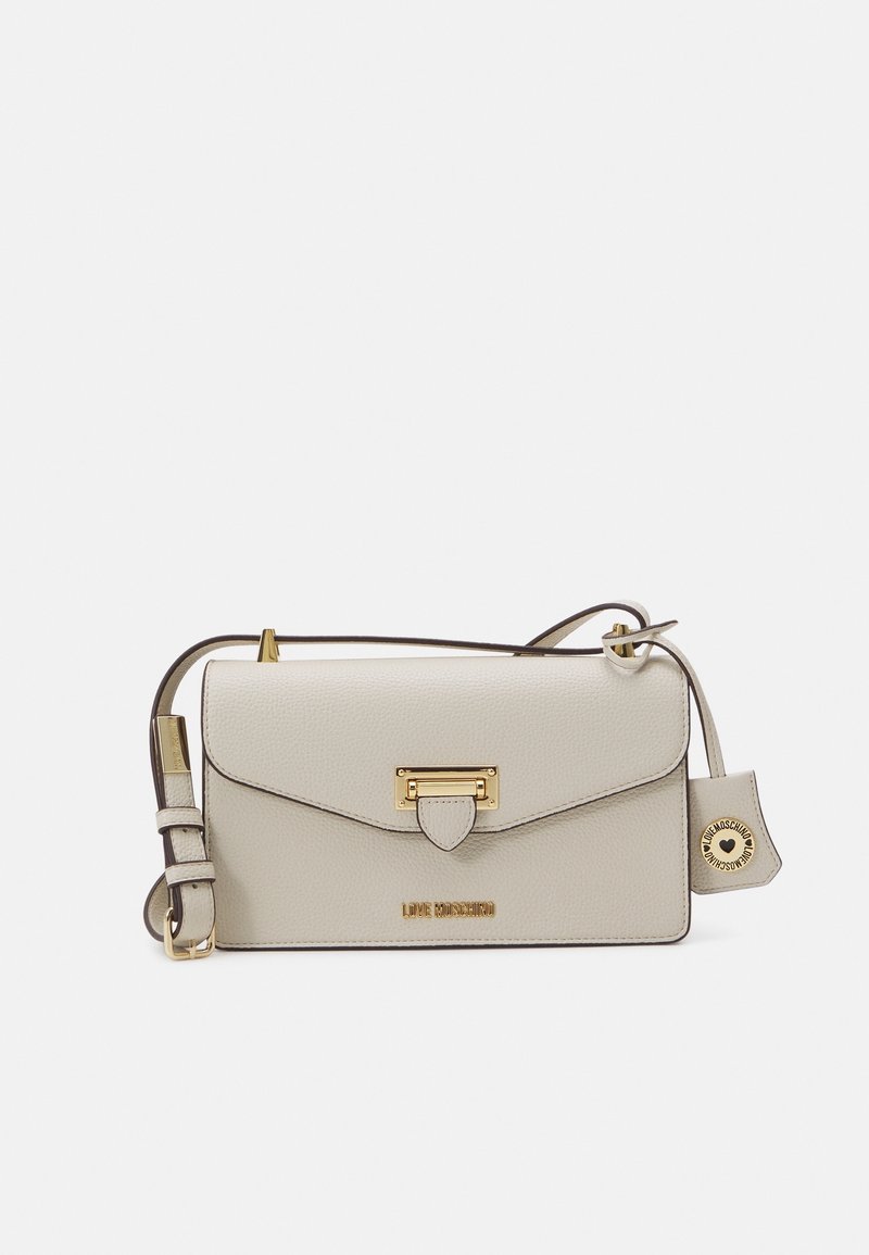 Borsa a tracolla in pelle beige con chiusura in oro, dettagli con zip e tracolla regolabile. Presenta un logo e un piccolo tag decorativo.