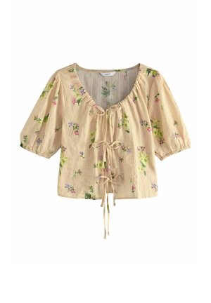 Beige short-sleeve blouse with small floral print and three front tie closures, featuring a rounded neckline and puffed sleeves.