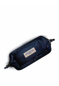 Navyblaue Reißverschlusstasche aus glattem Material. Enthält ein beiges Etikett mit blauer Schrift im Inneren. Rechteckige Form, minimalistisches Design.