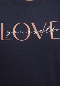 Marinblå bomulls T-shirt med en design som har texten "KÄRLEK" i ljus orange och "dig själv" i vit kursiv stil.