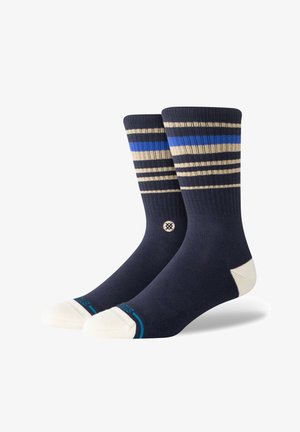 Calze blu navy con strisce beige e blu. Presentano una punta e un tallone in crema a contrasto. Bordi ribattuti e dettaglio del logo sul lato.