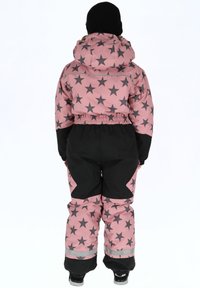 Roze en zwarte sneeuwpak met een sterrenpatroon, elastische taille en verstelbare manchetten, ontworpen voor warmte en bewegingsvrijheid.