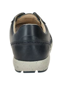 Zapato de piel azul marino con parte trasera redondeada y suela texturizada beige. Presenta costuras beige y un forro suave visible en la abertura.