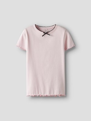 Haut rose clair à manches courtes côtelées avec bords festonnés, encolure bordée de noir et petit nœud noir au col.