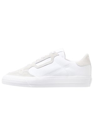 Weißer Sneaker mit niedrigem Schaft, Wildlederapplikationen, Schnürung vorne und strukturierter Gummisohle, seitliche Ansicht auf weißem Hintergrund.