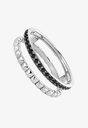 Dos anillos apilados: uno con un acabado plateado brillante, que presenta acentos texturizados en forma de pirámide; el otro adornado con piedras negras en una banda plateada.