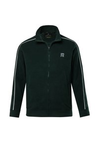 Giacca in micropile verde con zip, colletto alto, zip frontale e strisce bianche sui lati. Presenta un logo sul lato sinistro del petto. Texture morbida.