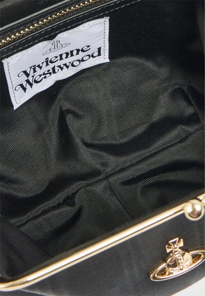 Εσωτερικό μαύρης υφασμάτινης τσάντας με λευκή ετικέτα μάρκας Vivienne Westwood και μεταλλικό πλαίσιο σε χρυσό τόνο με λογότυπο σφαίρας στην πρόσοψη.