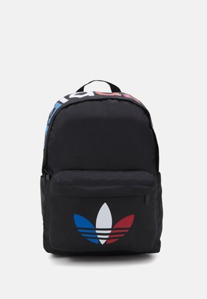 Czarny plecak z przednią kieszenią i trójkolorowym logo Adidas Trefoil w kolorach niebieskim, białym i czerwonym, wyposażony w uchwyt i zamknięcie na zamek.