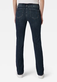 Jeans rectos azul oscuro con una textura de denim suave, que presentan dos bolsillos traseros y un diseño clásico de cinturilla.