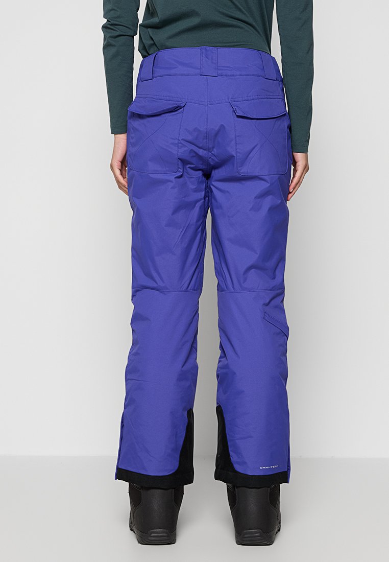 Pantaloni da sci viola con esterno impermeabile, polsini rinforzati e multiple tasche posteriori. Tessuto testurizzato e design aderente per facilitare il movimento.