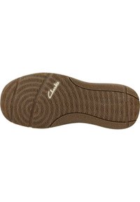 Suela de zapato de goma marrón con una textura ondulada y el logo de Clarks. Presenta patrones de banda de rodadura detallados para ofrecer agarre y un diseño aerodinámico.