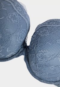 Krajková braletka v jemné modré barvě, s květinovými vzory, vycpanými košíčky a nastavitelnými ramínky. Strukturovaný povrch s vlnitými okraji.