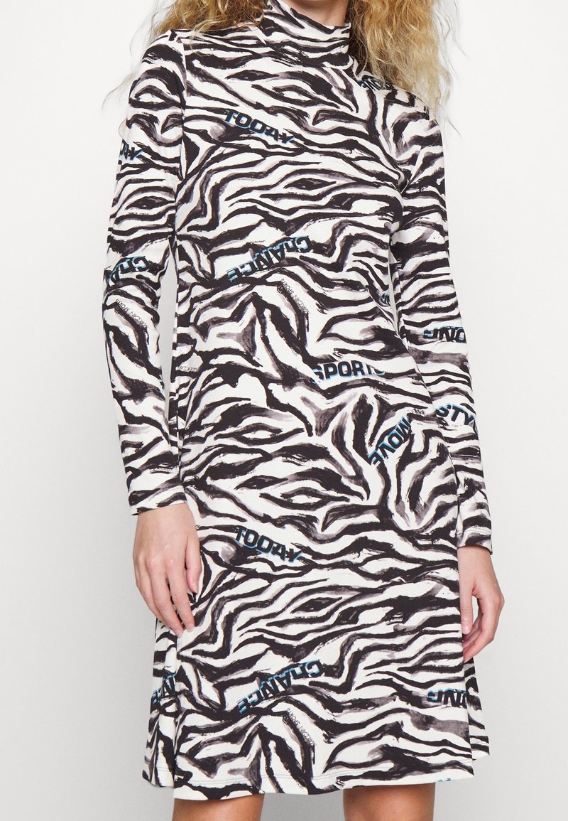 Langärmliges Kleid im creme- und schwarz gestreiften Zebra-Muster mit blauen Texthighlights. Bietet einen figurbetonten Rollkragen und ein ausgestelltes Rockdesign.