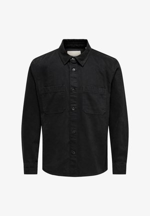 Čierna dlhá rukávová košeľa vyrobená z bavlny, s golierom na gombíky, dvoma prednými vreckami a rovnými lemami. Má hladkú, matnú textúru.