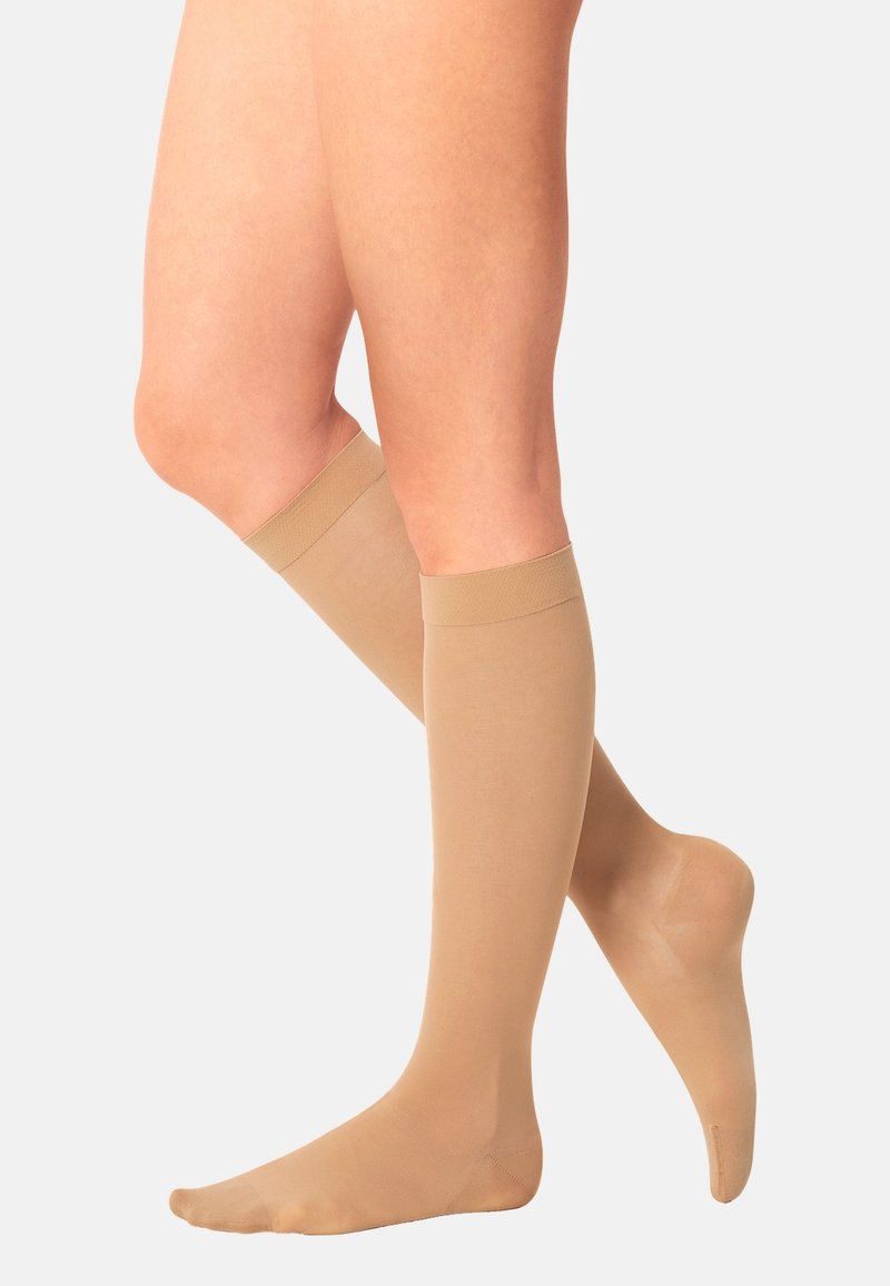 Knee-high compression socks in light beige, made from smooth material with a subtle sheen, featuring comfortable cuff and reinforced toe area.