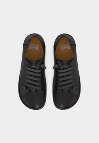 Paire de chaussures Camper Peu Cami en cuir noir à lacets, avec semelles intérieures marron, vues de dessus sur un fond blanc.