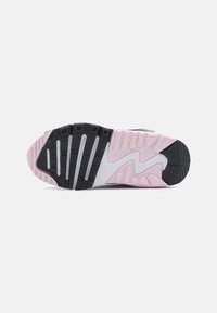 Súťažná podrážka Nike so štruktúrovanou čiernou gumou, ružovými a sivými akcentmi, s viacerými vzormi behúňa pre lepšiu priľnavosť a stabilitu.